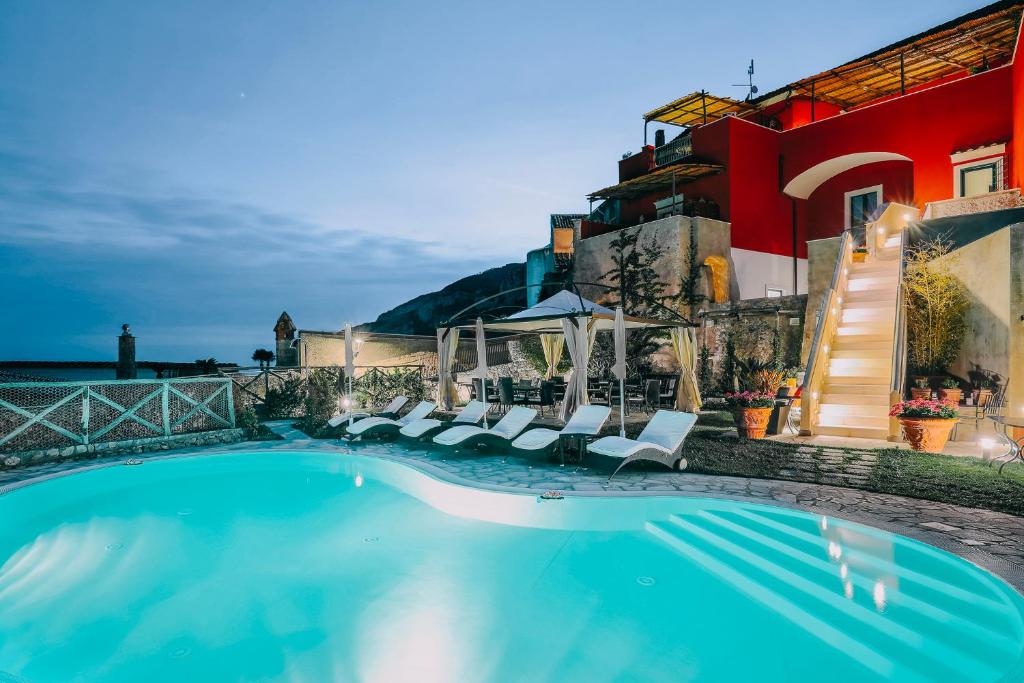 a swimming pool with chairs and a building at Palazzo Pascal in Scala