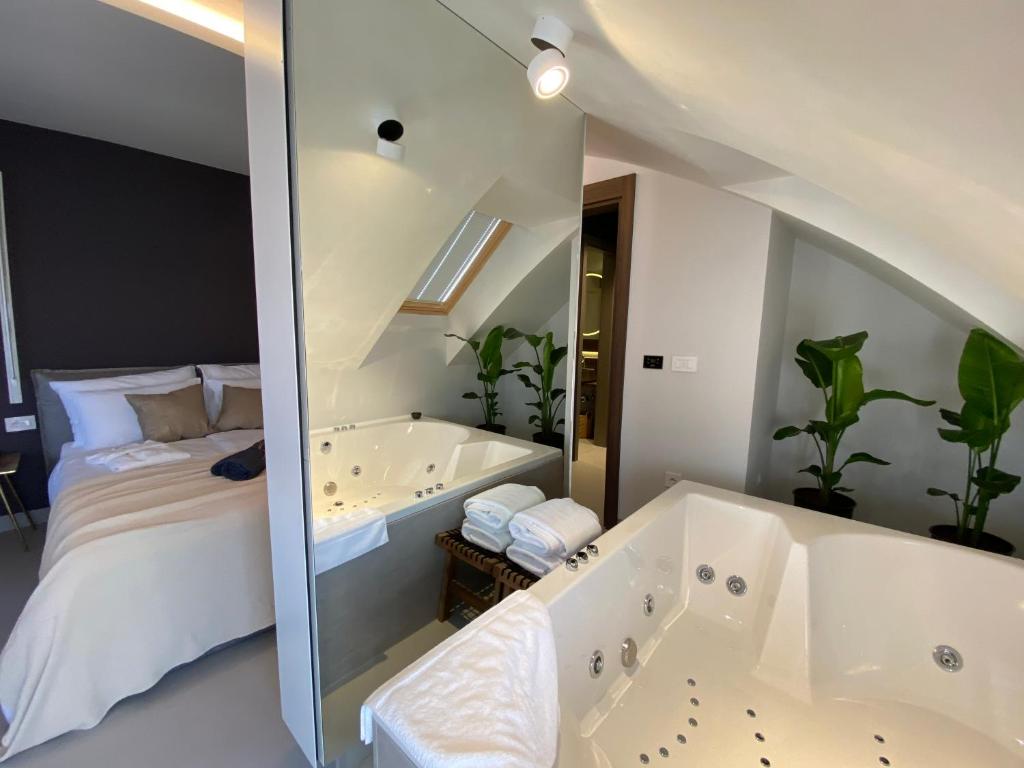 uma casa de banho com uma cama e uma banheira ao lado de um quarto em Korpa Deli Rooms SPA em Novi Sad