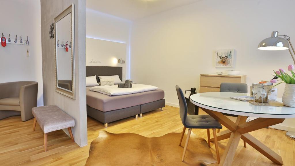 um quarto com uma cama e uma mesa e uma mesa e cadeiras em Hotel Prinz Carl - Apartments mit Klimaanlage em Neckarsulm