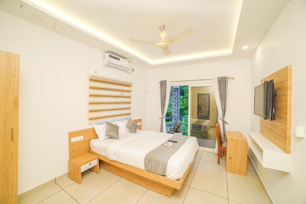 um quarto com uma cama e uma televisão em Oceana Hills Residency em Alappuzha