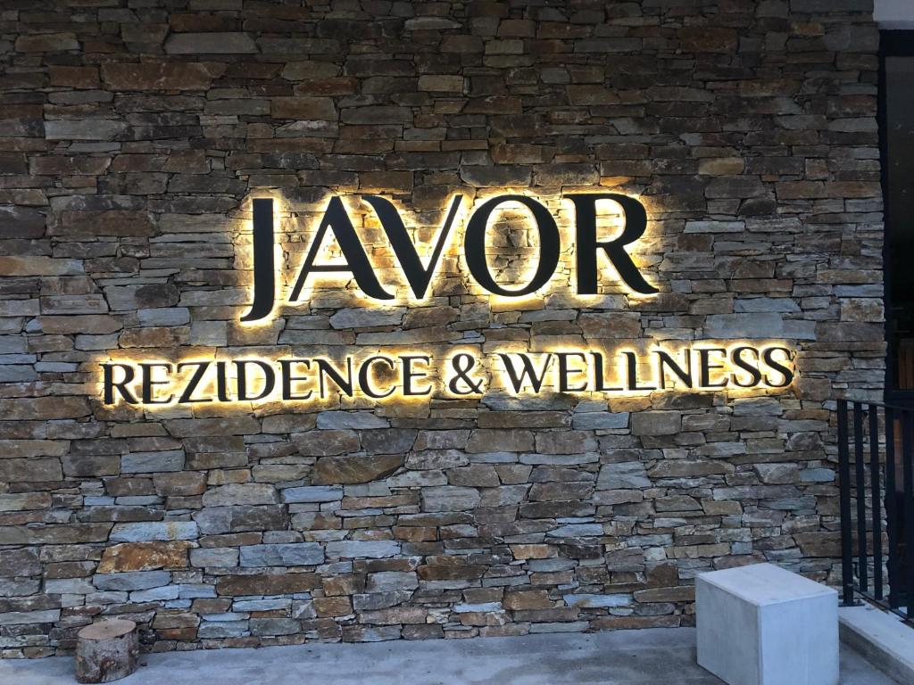 ein Schild an einer Backsteinwand, das Dampfwiderstand und Wellness liest in der Unterkunft JAVOR - Rezidence & Wellness in Železná Ruda