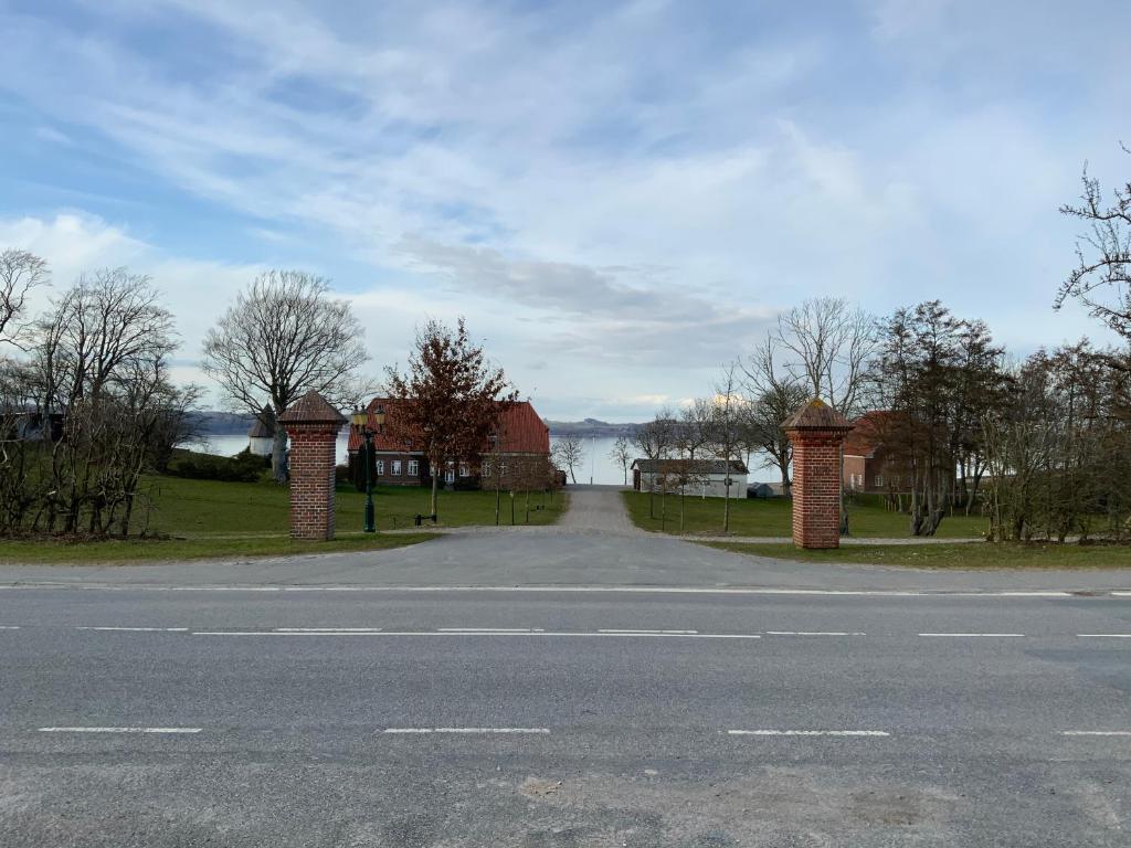 una strada vuota accanto a una casa con vista sull'acqua di Loff Holiday Houses a Aabenraa