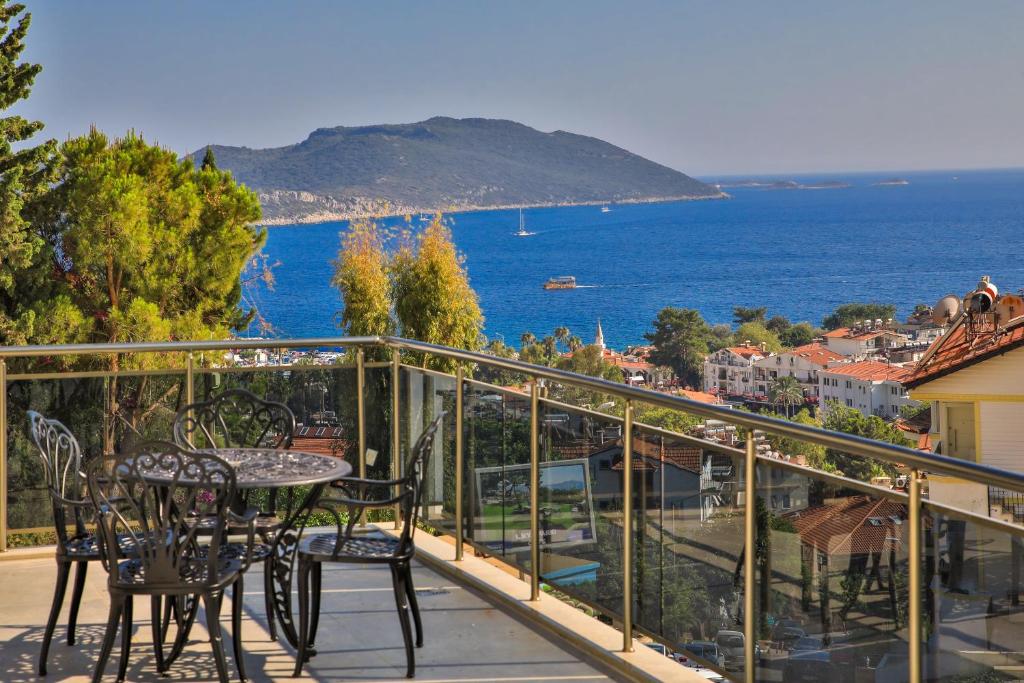 einen Balkon mit einem Tisch, Stühlen und Meerblick in der Unterkunft Happy Kaş Apart in Kaş