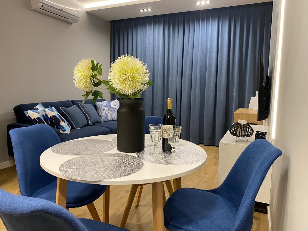 ein Wohnzimmer mit einem Tisch mit blauen Stühlen und einem Sofa in der Unterkunft Family & Business Elegant Apartments Wspólna Centrum Downtown - 1 Bedroom, Terrace, Air Conditioning, Garage, NEW! in Kielce