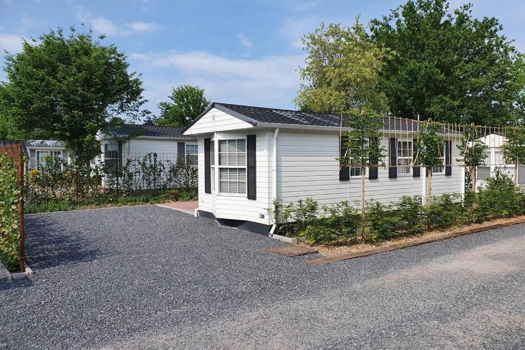 une maison blanche avec une clôture devant elle dans l'établissement Vazonics Valkenbosch 76, à Oisterwijk