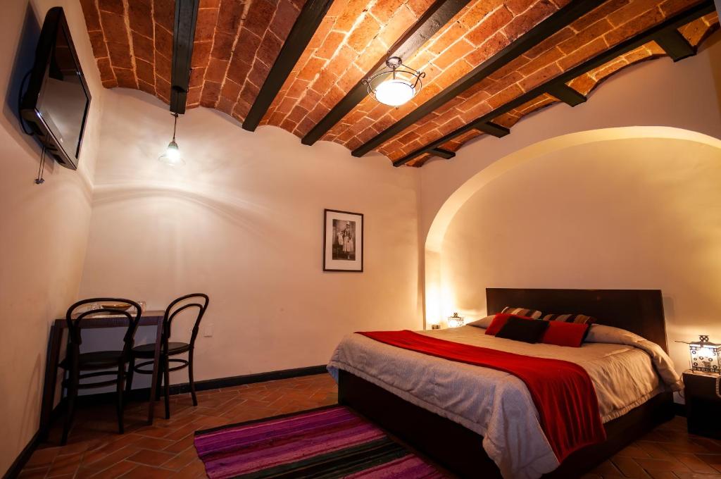 a bedroom with a bed and a table and chairs at Hotel Naira in La Paz