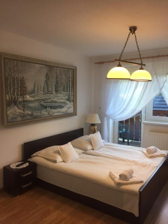 een slaapkamer met een groot bed en een raam bij Willa Panorama in Szczyrk