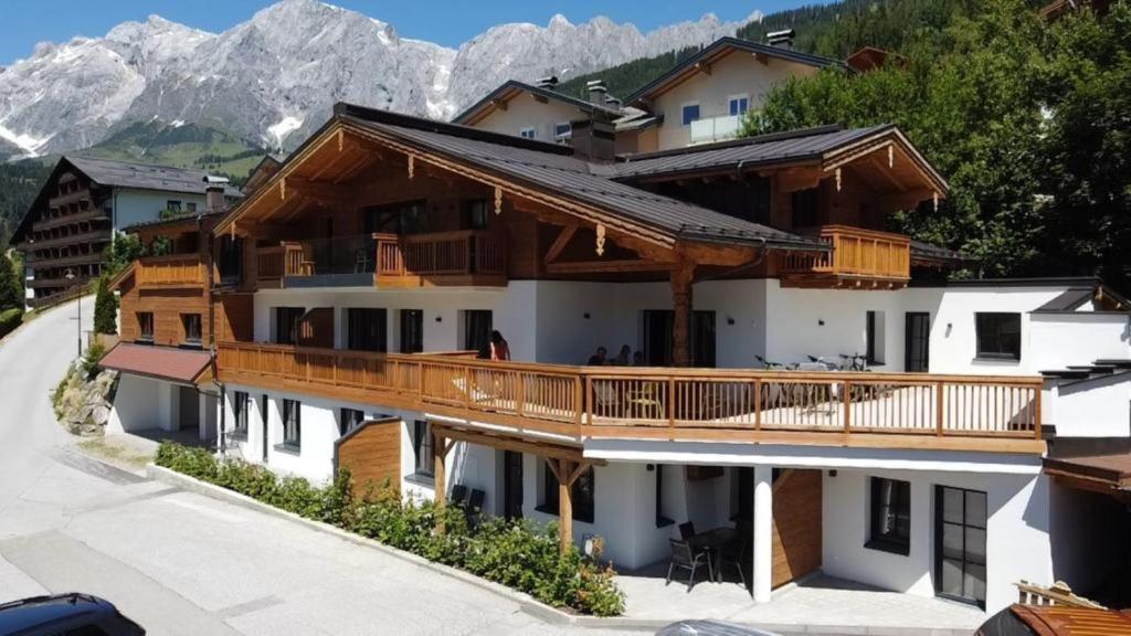 een huis met een balkon met bergen op de achtergrond bij Hochkönig Ferien in Mühlbach am Hochkönig