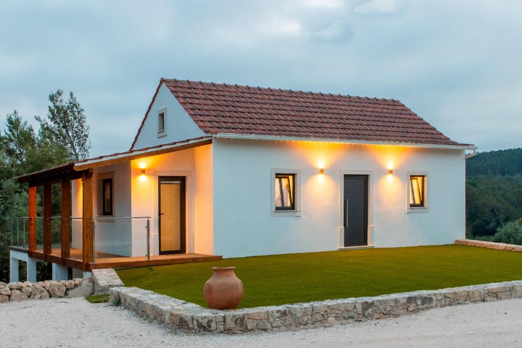 a small white house with a vase in front of it at Casa Marmelos - Alojamento Local in Ourém