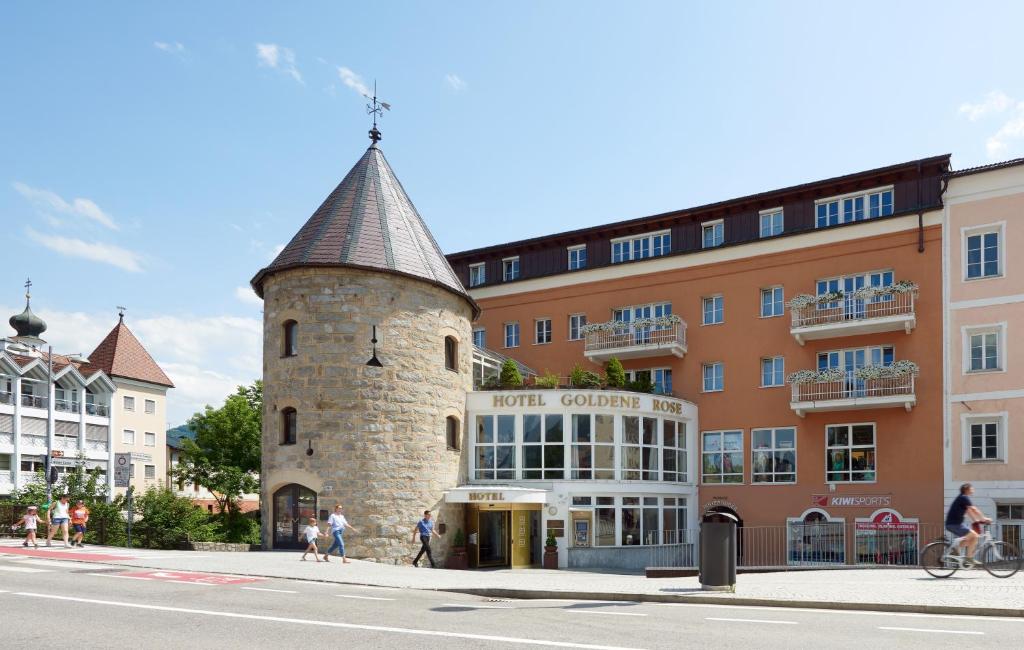 un edificio con una torre en medio de una calle en Hotel Goldene Rose, en Brunico