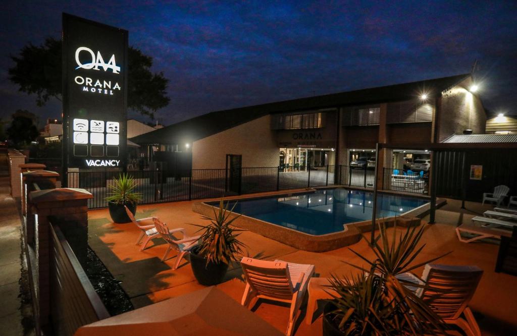 una piscina frente a un edificio por la noche en Orana Motel, en Dubbo