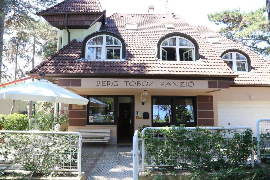 um edifício com um sinal que diz berg toto pampapo em Berg Toboz Panzió em Pécs