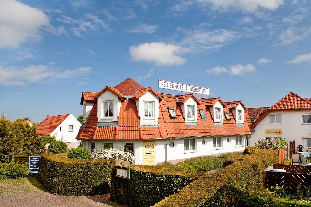 uma casa branca com um telhado laranja em Ferienhotel Bernstein em Trassenheide