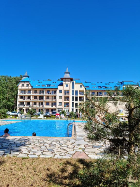 un hotel con piscina frente a un edificio en BLUE MARE Apartamenty MES, en Łukęcin