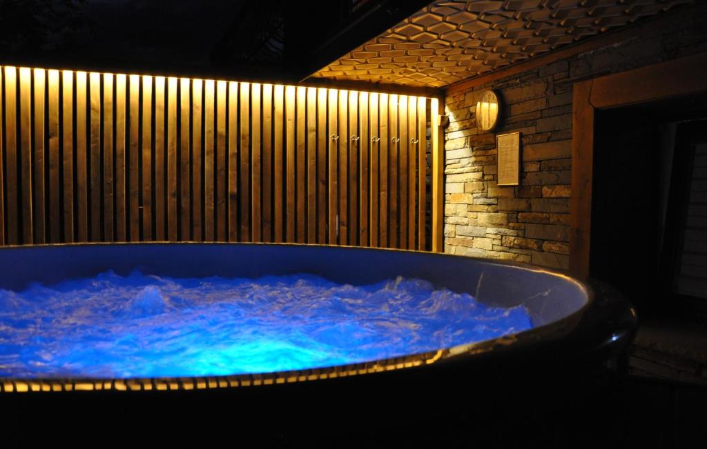 - une baignoire jacuzzi avec eau bleue dans la chambre dans l'établissement WIlla JODŁA JACUZZI&SAUNA, à Poronin