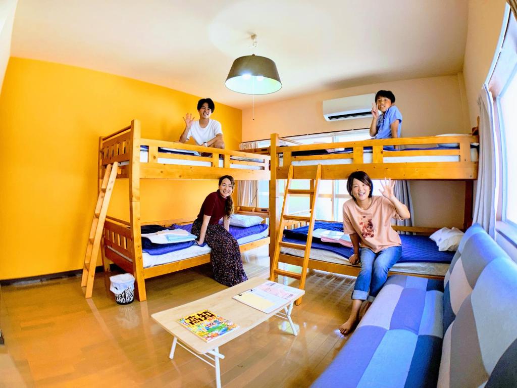 een groep mensen in een kamer met stapelbedden bij ルルルあたご 3〜6名に最適 家族＆グループ向き ゆったり1Rアパートタイプ in Kochi