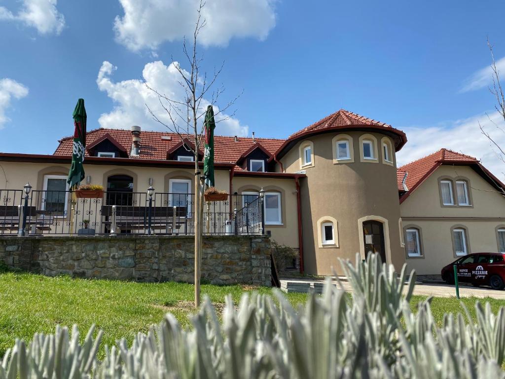 une grande maison avec un drapeau devant elle dans l'établissement Hotel & Restaurace Pizzerie Jasany, à Znojmo