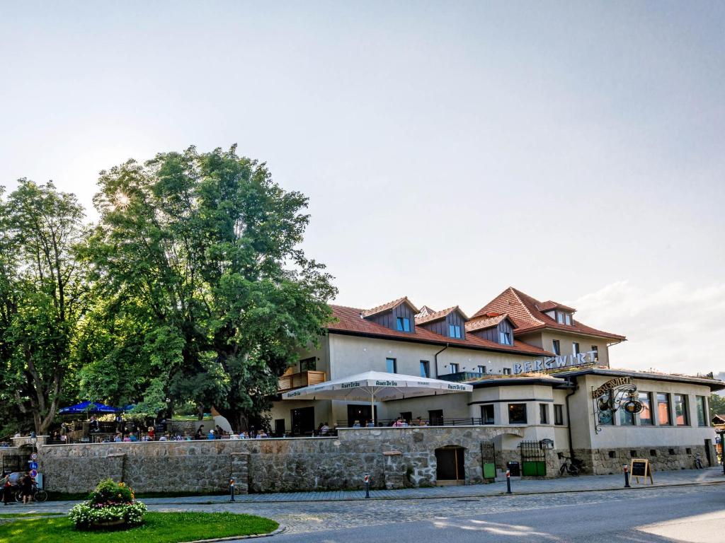 Ein Gebäude mit Leuten, die draußen sitzen. in der Unterkunft Bergwirt Hotel & Gasthof in Kiefersfelden