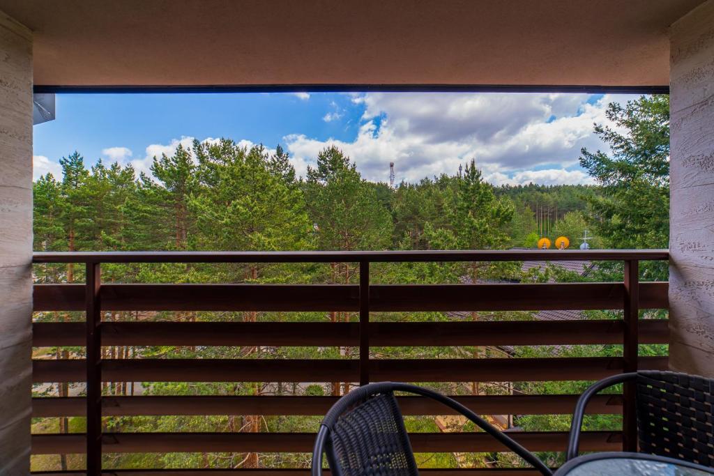 a view from a balcony with chairs and trees at Vila Pekovic, Pine Trees View Apartment with big balcony in The Center of Zlatibor! in Zlatibor