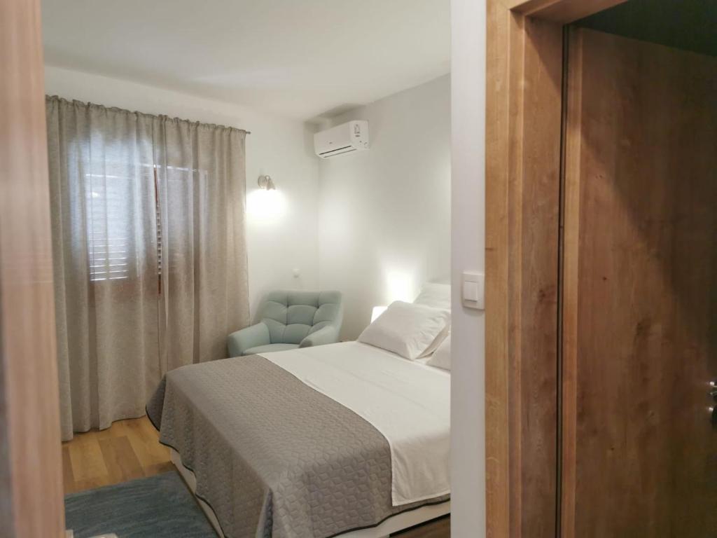 1 dormitorio con 1 cama y 1 silla azul en Apartman Kneže, en Korčula