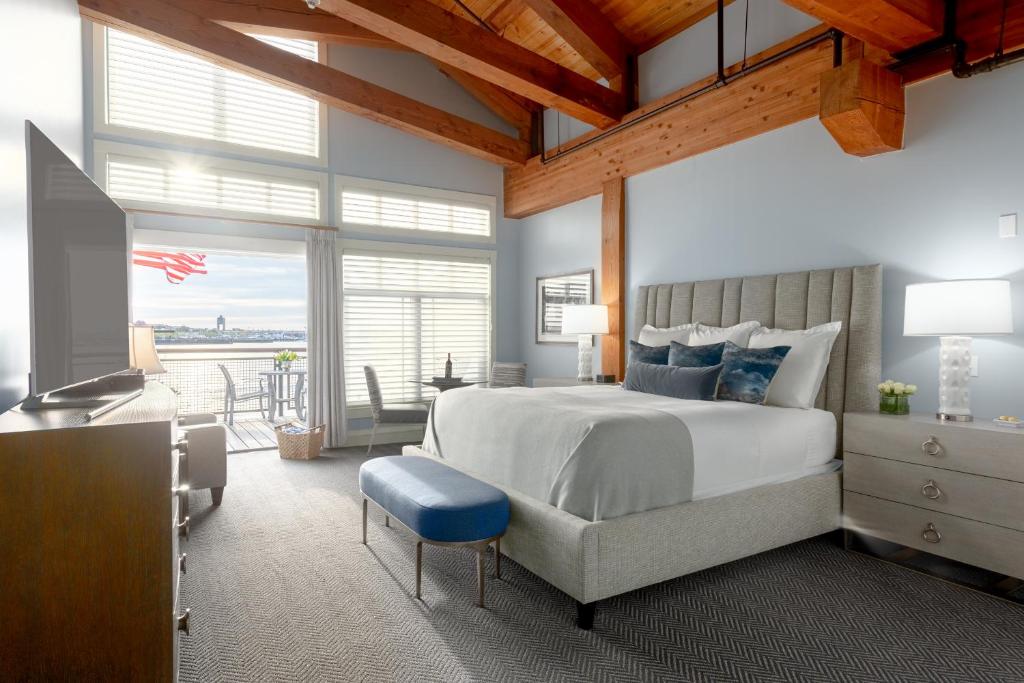 - une chambre avec un grand lit et un tabouret bleu dans l'établissement Boston Yacht Haven, à Boston