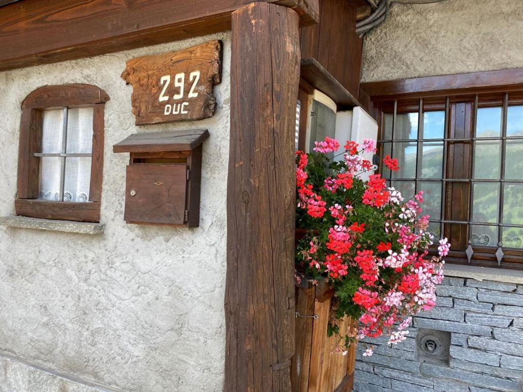 a sign on the side of a building with flowers at Frazione Duc Apartments in Sestriere