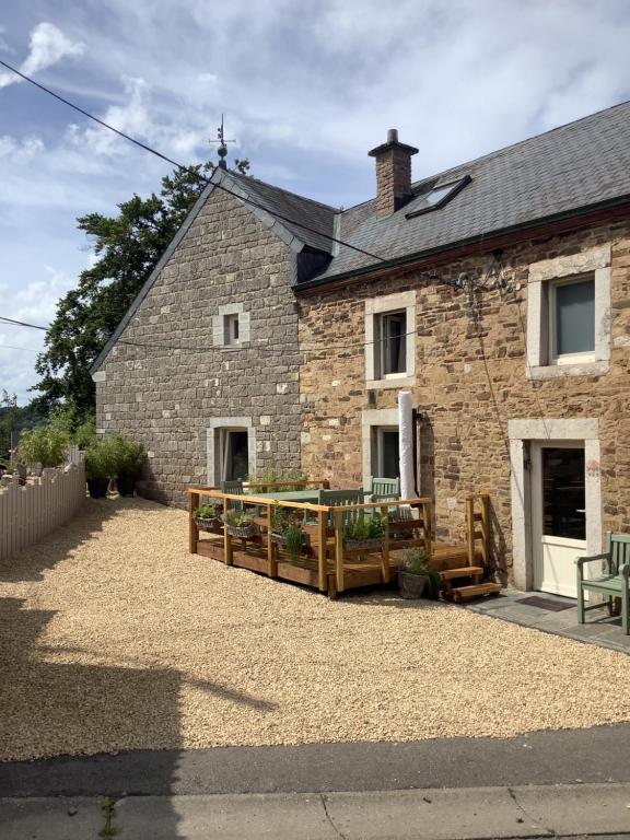 een stenen huis met een houten terras ervoor bij La Fagnoul in Ferrières