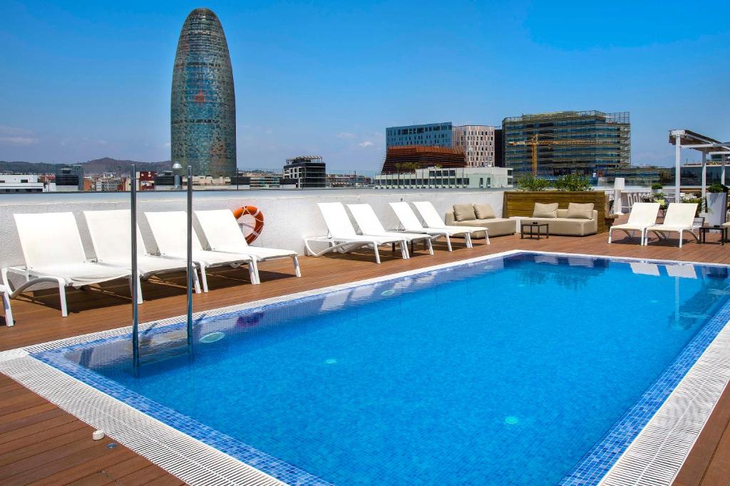 une piscine sur le toit d'un bâtiment dans l'établissement Golden Hotel Barcelona, à Barcelone