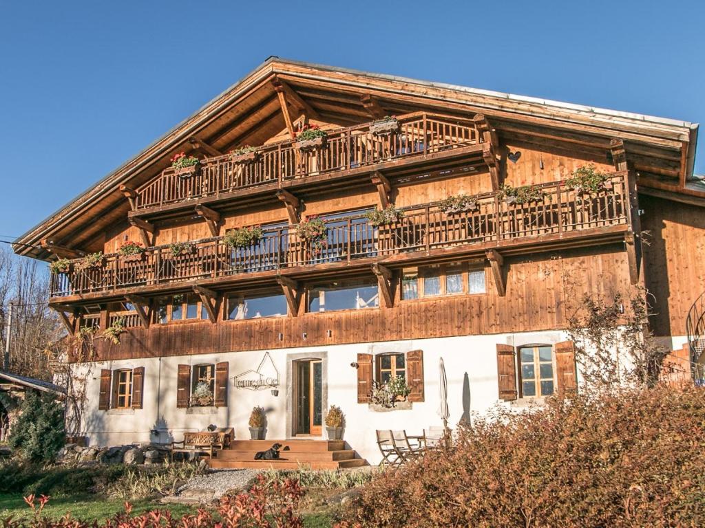 een groot houten huis met een balkon. bij Ferme du Ciel in Samoëns