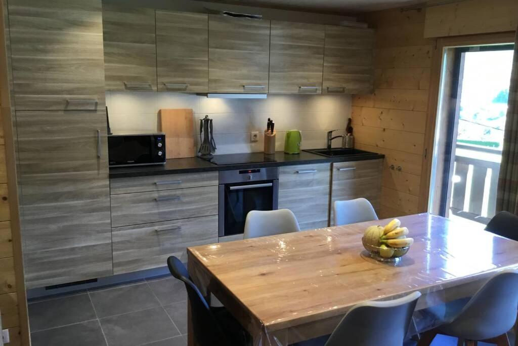 uma cozinha com uma mesa com uma tigela de bananas em Modern Comfortable Chalet with large terrace em Morzine