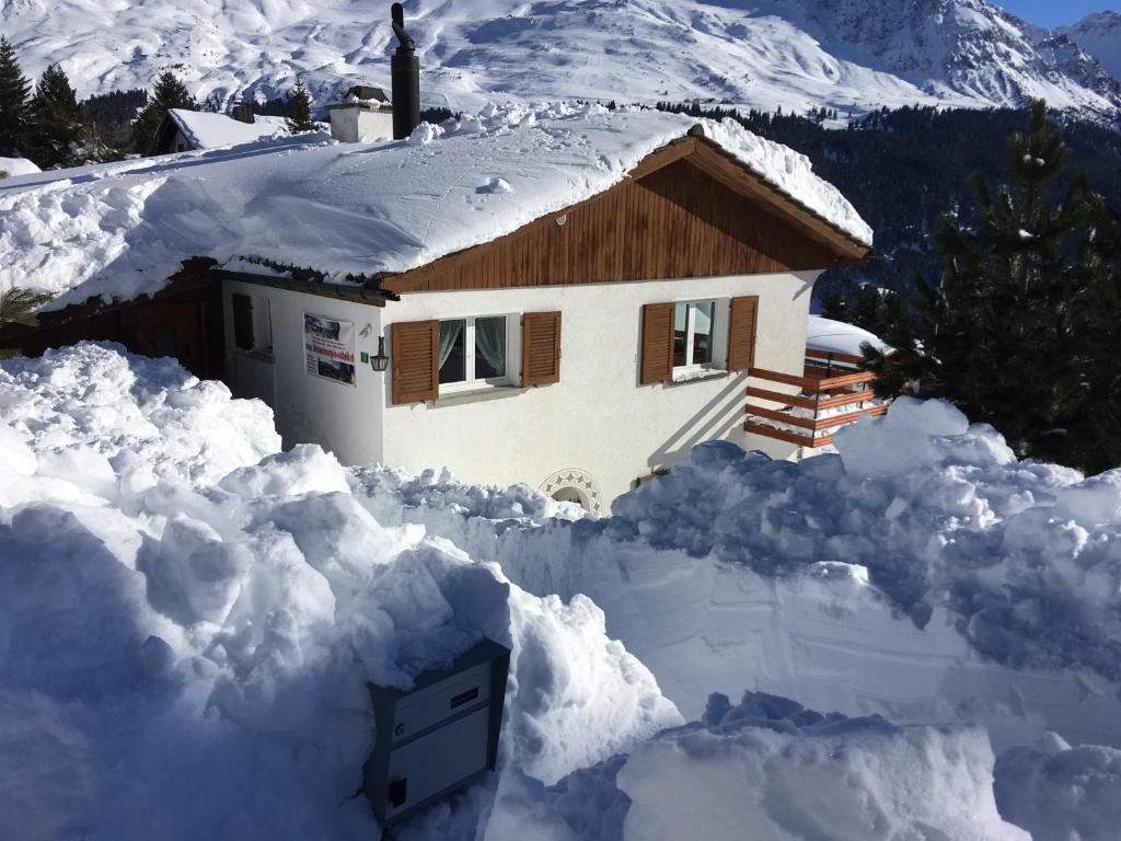 ein Haus ist mit Schnee bedeckt in der Unterkunft Haus Tgamotsch***- Ferienwohnung in Valbella in Valbella