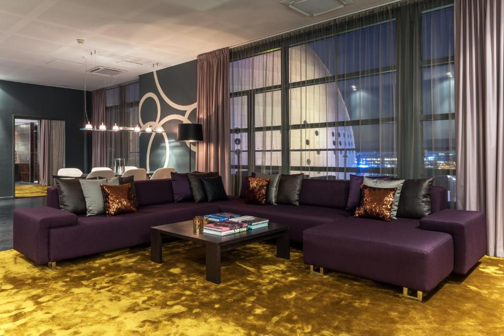 - un salon avec des canapés violets et une table dans l'établissement Quality Hotel Globe, à Stockholm