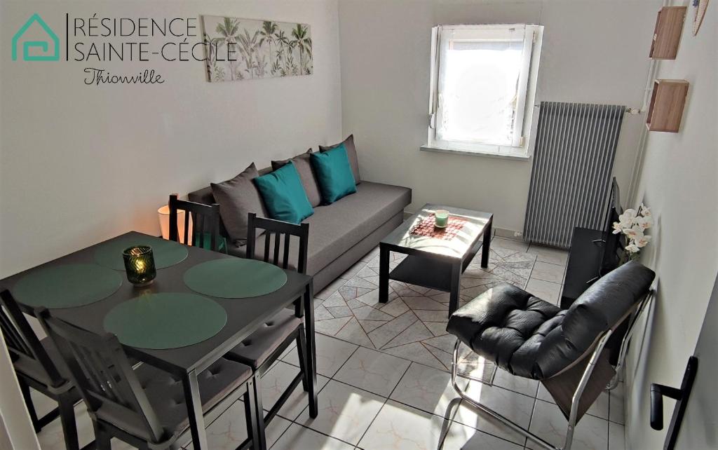 a living room with a table and a couch at Résidence Sainte Cécile in Thionville