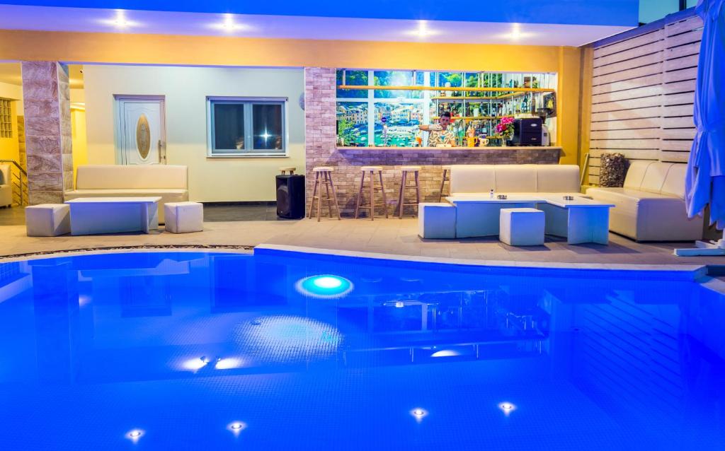 una piscina en una sala de estar con mesa y sillas en ALDEBARAN HOMES, en Limenaria