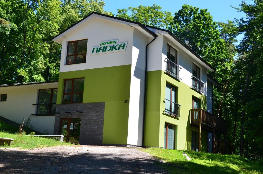 a yellow and green building with a sign on it at Penzión NADKA in Bojnice