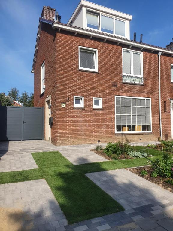 une maison en briques avec une pelouse devant elle dans l'établissement Guesthouse de Hoogkamp, à Arnhem