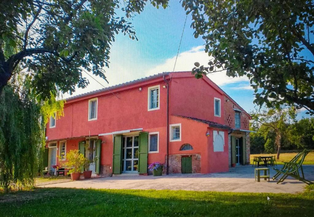 un fienile rosso con un tavolo da picnic di fronte di Colonica Il Picchio Verde ad Altopascio