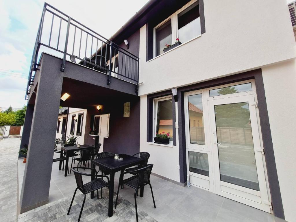 a patio with black tables and chairs on a building at Holdudvar Apartman in Gyula