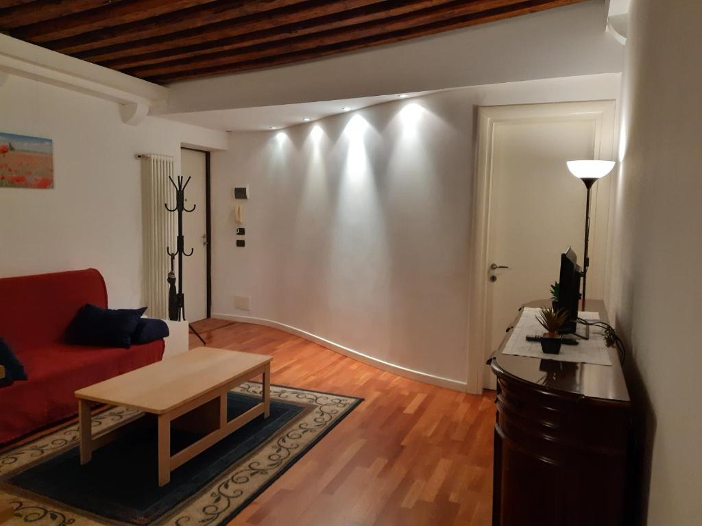 een woonkamer met een rode bank en een tafel bij Residenza Campo Ruga in Venetië