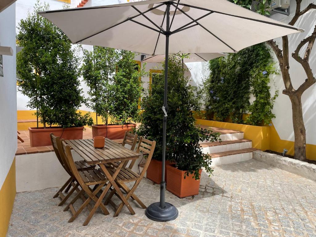 un tavolo e sedie con ombrellone su un patio di Casa Carmo a Évora