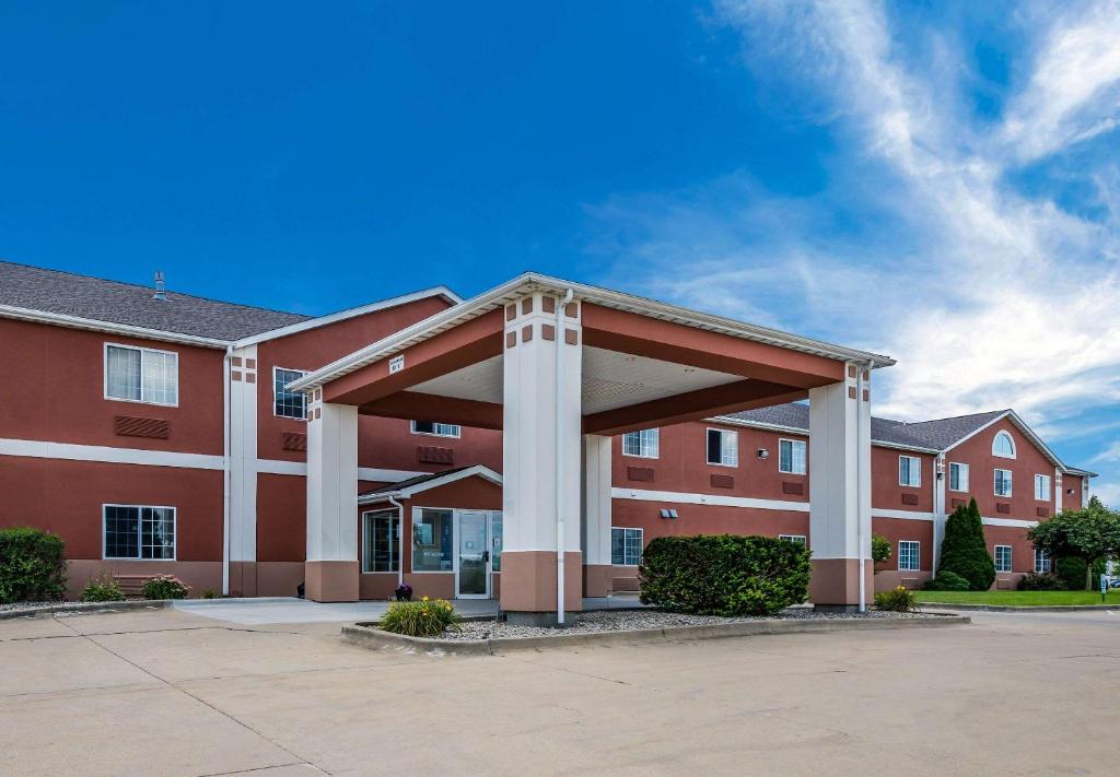 Rodeway Inn Urbana Champaign University Area في شامبين: مبنى أحمر كبير مع موقف للسيارات