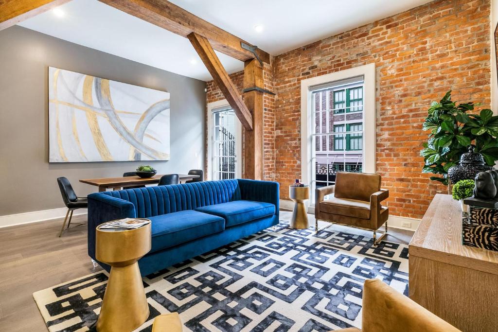 a living room with a blue couch and a brick wall at The Calliope in New Orleans