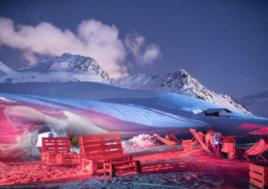 un gruppo di sedie rosse e una montagna innevata di Village Igloo Les Arcs ad Arc 2000