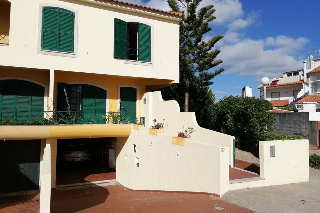 a white house with green shuttered windows and stairs at Beach House Villa At Peniche - Praia Consolação in Atouguia da Baleia