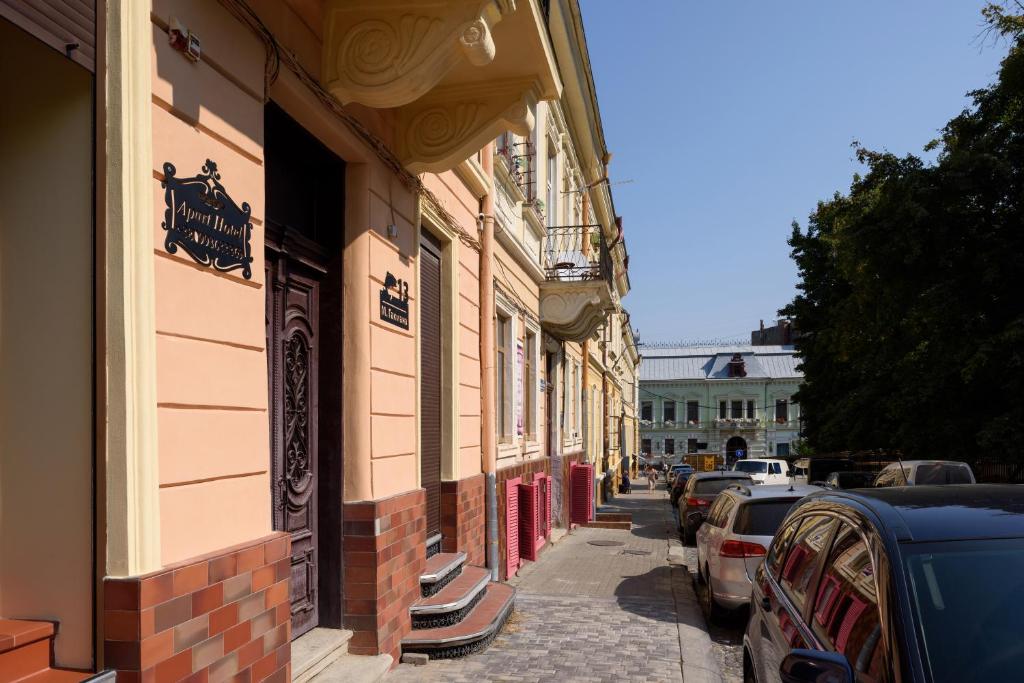 uma rua com carros estacionados ao lado de um edifício em Apart Hotel Fusion em Chernivtsi