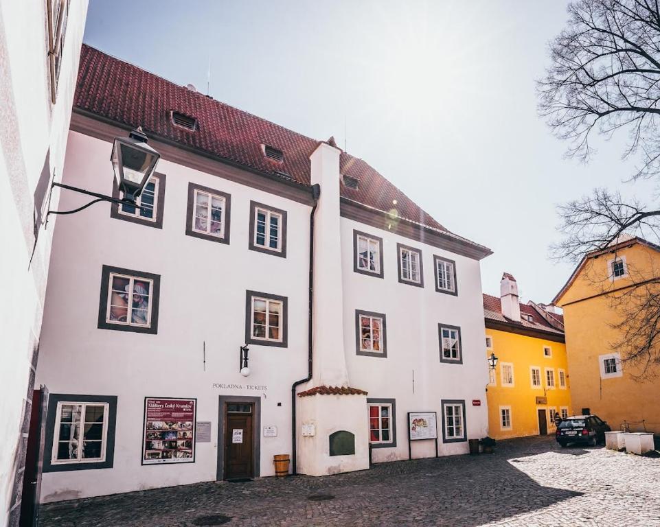 un edificio bianco con tetto rosso di Klášterní apartmány a Cesky Krumlov