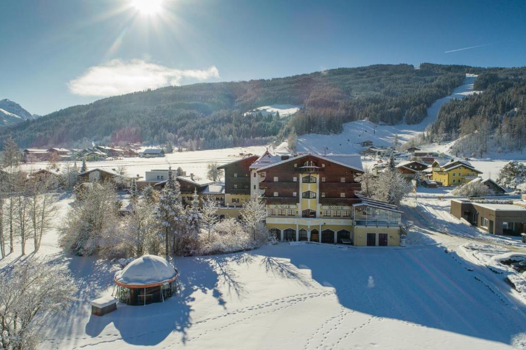 un resort nella neve con il sole sullo sfondo di Hotel Zum Jungen Römer a Radstadt