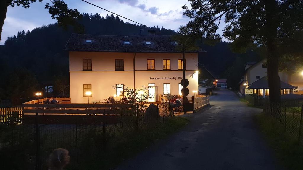 um grande edifício branco com um restaurante em frente em Penzion Klášterský mlýn em RejÅ¡tejn