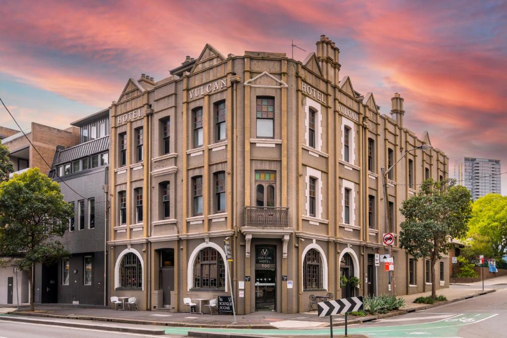 een oud gebouw op de hoek van een straat bij Vulcan Hotel Sydney in Sydney