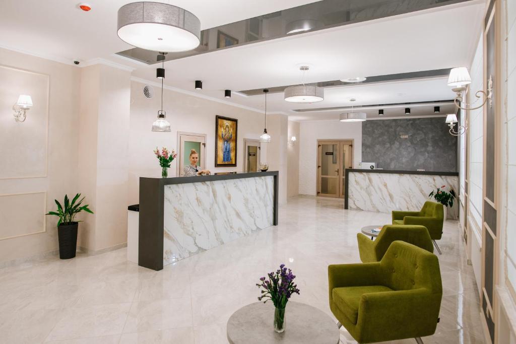 a lobby with green chairs and a reception desk at ОРАНТА in Truskavets